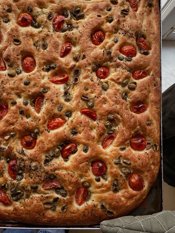 Italian focaccia with olives and cherry tomatoes, perfect for a savory meal.